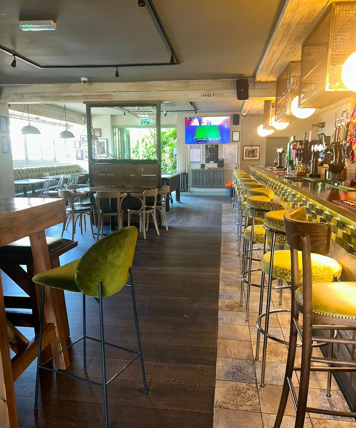 The long bar with yellow stools and globe lights