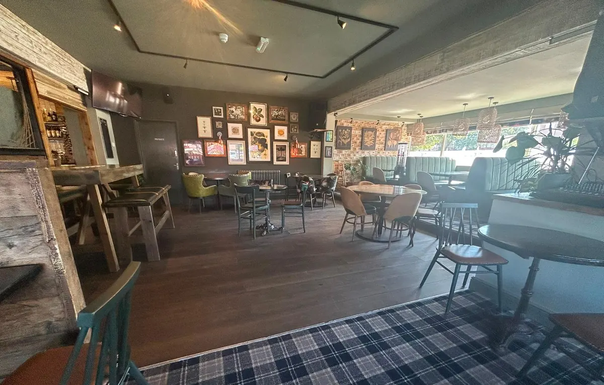 The main seating area, with tables, booths and a wall of framed prints