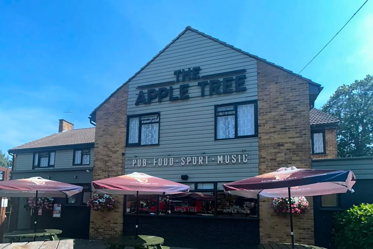 The front of The Apple Tree on Broom Road, with parasols over the beer garden