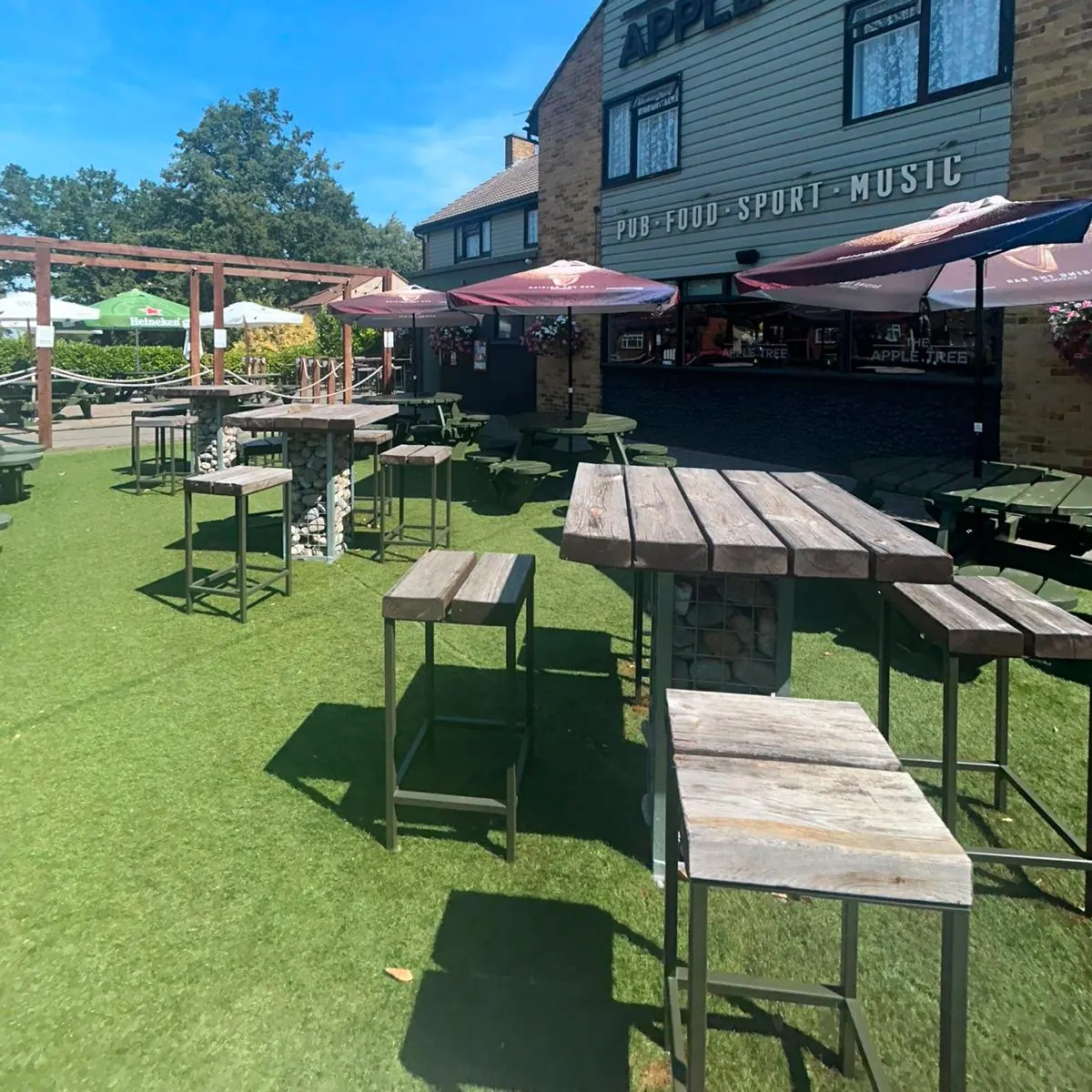 Picnic benches and parasols across the beer garden on a sunny day