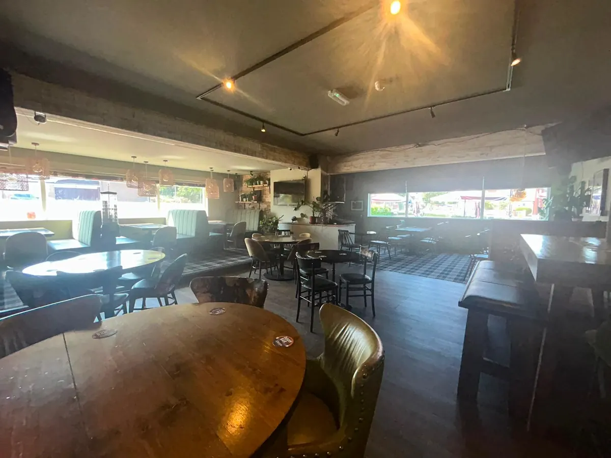 Round tables and green armchairs inside the pub