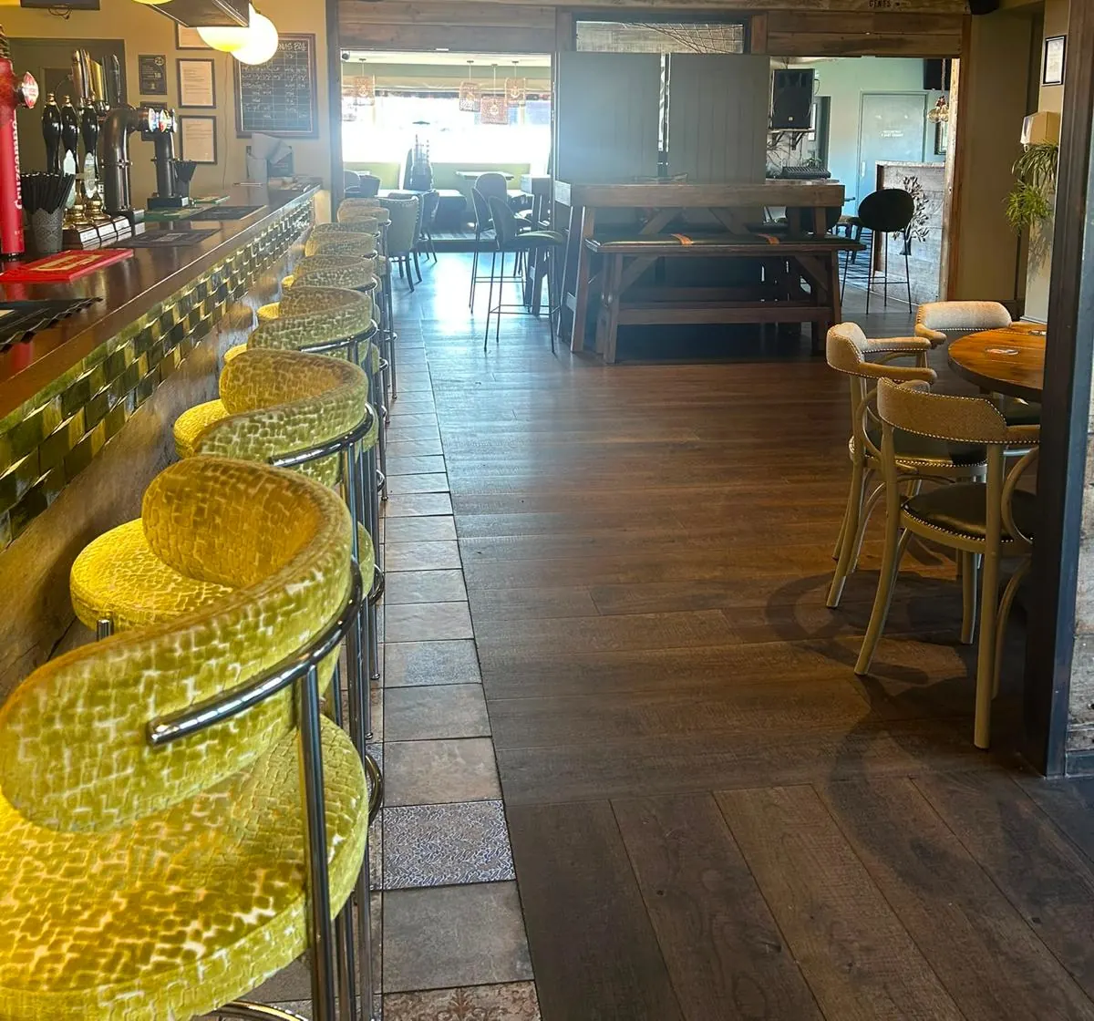 Yellow velvet bar stools along the bar