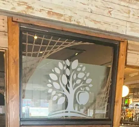 The etched apple tree on the glass screen inside the pub